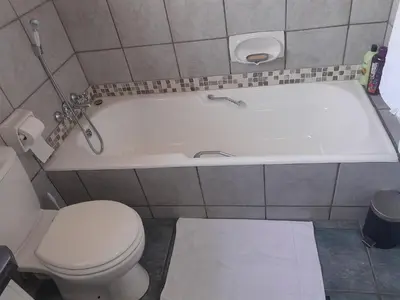 a bathroom with a toilet and a bath tub at TANS - 1 bedroom luxury & cosy home walking distance to Doringkloof Mall in Centurion