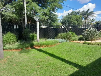 a shadow of a fence in a yard at TANS - 1 bedroom luxury & cosy home walking distance to Doringkloof Mall in Centurion