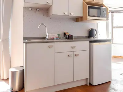 a kitchen with white cabinets and a sink at Amalfi Place in Pretoria
