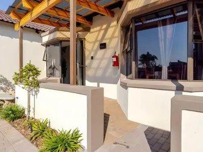 a house with a white wall and a fence at Amalfi Place in Pretoria