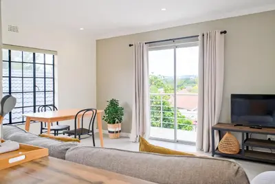 a living room with a couch and a large window at Waterfall Views in Midrand