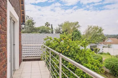 a balcony with a white fence and flowers at Waterfall Views in Midrand