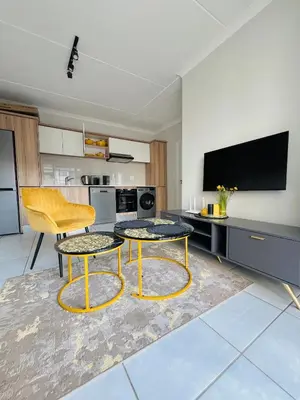 a living room with two tables and a tv at The Blyde Lagoon in Pretoria