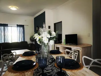 a living room with a table with a vase of flowers at Moll & Kie Luxury Accommodation in Burgersfort