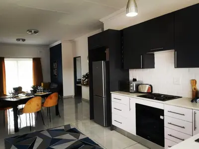 a kitchen with black cabinets and a black refrigerator at Moll & Kie Luxury Accommodation in Burgersfort