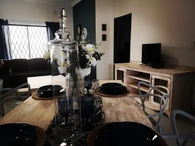 a dining room with a table with a vase of flowers at Moll & Kie Luxury Accommodation in Burgersfort