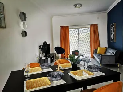 a living room with a table and a couch at Moll & Kie Luxury Accommodation in Burgersfort