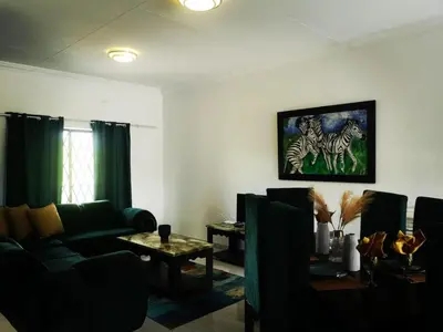 a living room with a couch and a table at Moll & Kie Luxury Accommodation in Burgersfort