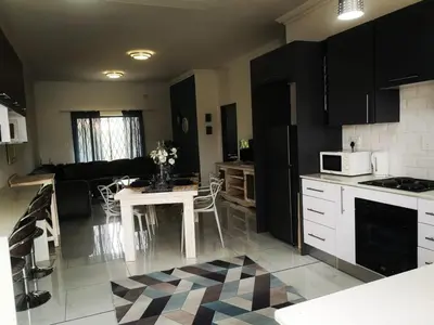 a kitchen with black cabinets and a table with flowers on it at Moll & Kie Luxury Accommodation in Burgersfort