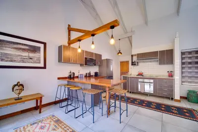 a kitchen with a table and some stools in it at Brooklyn Self Catering - walking distance to University of Pretoria in Pretoria