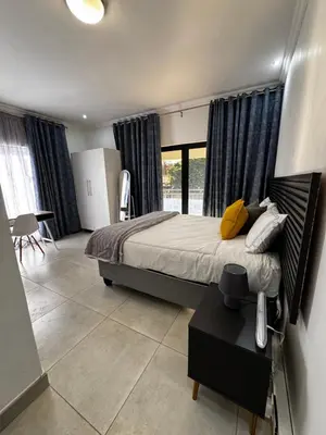 a bedroom with a bed and a large window at El-Gibbor Residence 1 in Ermelo