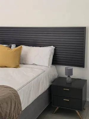 a bed with a black headboard and a table with a lamp at El-Gibbor Residence 1 in Ermelo