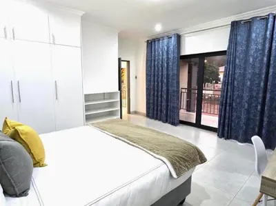 a bedroom with a bed and a large window at El-Gibbor Residence 1 in Ermelo