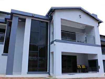 a large white house with a balcony at El-Gibbor Residence 1 in Ermelo