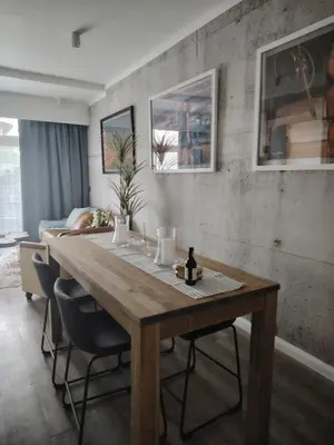 a dining room with a wooden table and chairs at Menlyn Maine Trilogy Apartment 519 in Pretoria
