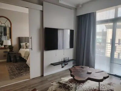 a living room with a tv on a wall at Menlyn Maine Trilogy Apartment 519 in Pretoria