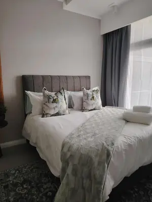 a bedroom with a large bed with white sheets and pillows at Menlyn Maine Trilogy Apartment 519 in Pretoria