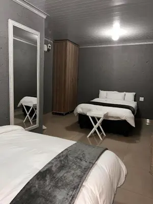 a bedroom with two beds and a mirror at The Essence Resort in Clarence