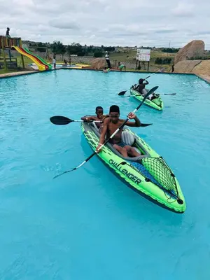 two people in a kayak in the blue water at The Essence Resort in Clarence