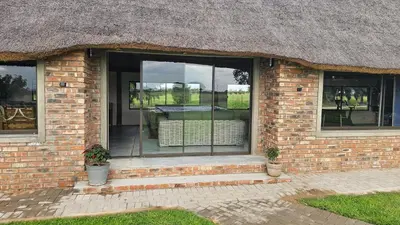a brick house with a window with a table in it at Die Pekanneut in Polokwane