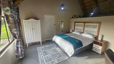 a bedroom with a large bed and a window at Die Pekanneut in Polokwane