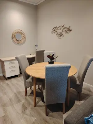 a dining room with a wooden table and chairs at Menlyn Maine Trilogy 1417 in Pretoria