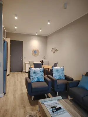 a living room with a couch and chairs and a table at Menlyn Maine Trilogy 1417 in Pretoria