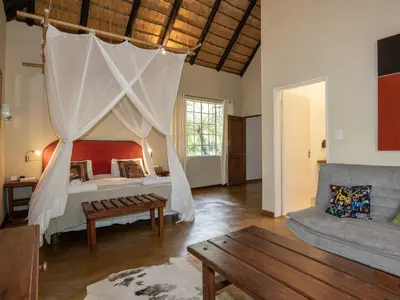 a bedroom with a canopy bed and a couch at Seringa Lodge & Safaris in White River
