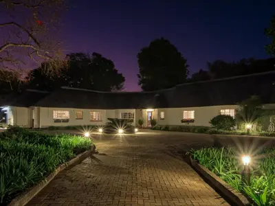 a house at night with lights on the driveway at Seringa Lodge & Safaris in White River