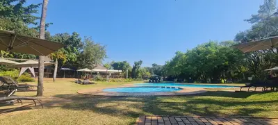 a swimming pool in the middle of a park at Kruger Park Lodge 243 in Hazyview