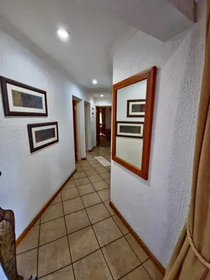 a hallway with white walls and pictures on the wall at Kruger Park Lodge 243 in Hazyview