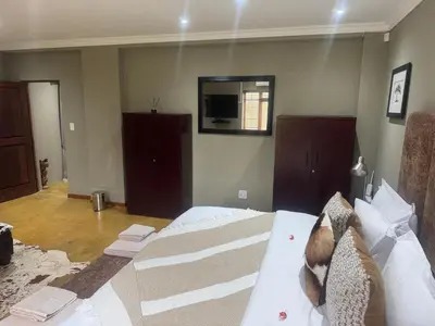 a bedroom with a bed and a mirror in it at Mountain Dew Quest House in Noordkaap