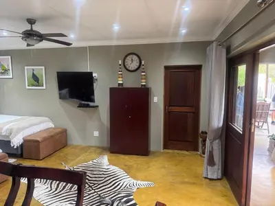 a bedroom with a bed and a clock on the wall at Mountain Dew Quest House in Noordkaap