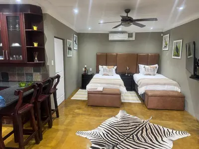 a large bedroom with two beds and a zebra rug at Mountain Dew Quest House in Noordkaap