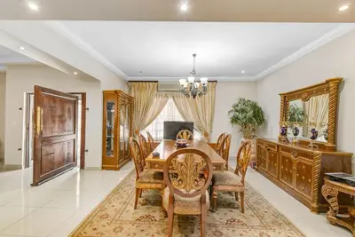 a dining room with a wooden table and chairs at Aaybee Recreational Home in Midrand