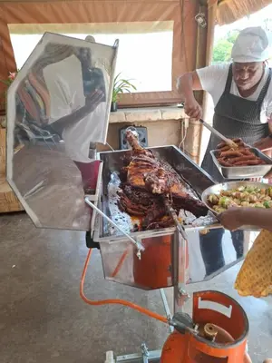 a man preparing a grill with meat and other food at Aaybee Recreational Home in Midrand