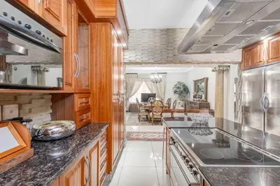 a kitchen with wooden cabinets and a counter top at Aaybee Recreational Home in Midrand