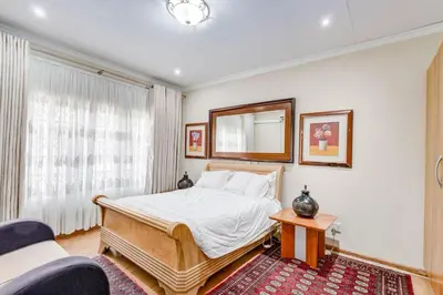 a bedroom with a bed and a mirror on the wall at Aaybee Recreational Home in Midrand
