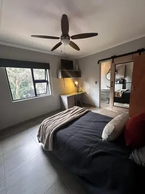 a bedroom with a bed and a ceiling fan at Core accomodations in Pretoria