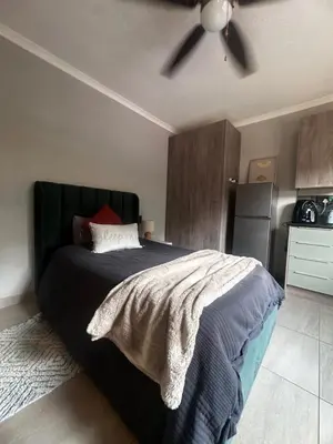 a bedroom with a bed with a ceiling fan at Core accomodations in Pretoria