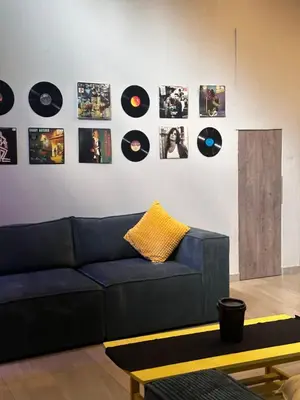 a living room with a blue couch and a wall with records at Core accomodations in Pretoria