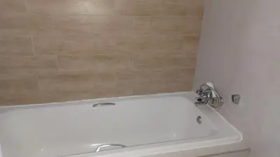 a bathroom with a white tub and a sink at Generous Apartment at Waterfall in Midrand