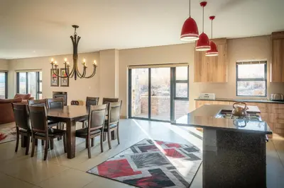a kitchen and dining room with a table and chairs at Highland Gate Golf & Trout Estate, House 910 in Dullstroom
