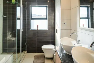 a bathroom with a toilet and a sink and a shower at Highland Gate Golf & Trout Estate, House 910 in Dullstroom