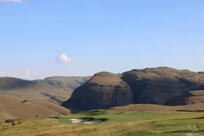 a golf course with a mountain in the background at Highland Gate Golf & Trout Estate, House 910 in Dullstroom