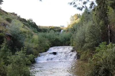 a waterfall on a river in a forest at Highland Gate Golf & Trout Estate, House 910 in Dullstroom