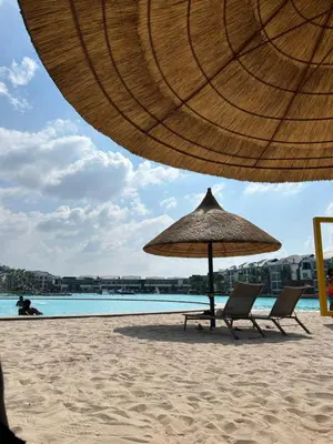 a beach with two chairs and an umbrella on the sand at The Blyde Crystal Lagoon in Pretoria