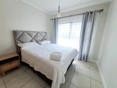 a bedroom with a white bed and a window at The Blyde Crystal Lagoon in Pretoria