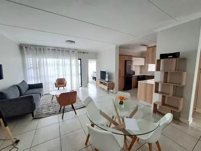 a living room with a glass table and a couch at The Blyde Crystal Lagoon in Pretoria