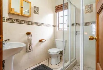 a bathroom with a toilet and a sink and a shower at Mapula in Marloth Park